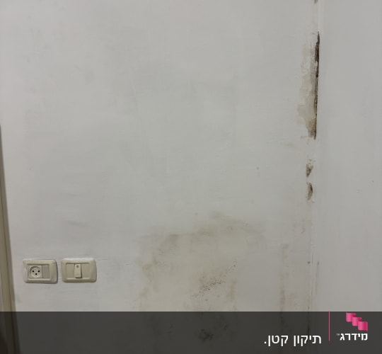 קיר עם כתמי רטיבות ושקעי חשמל